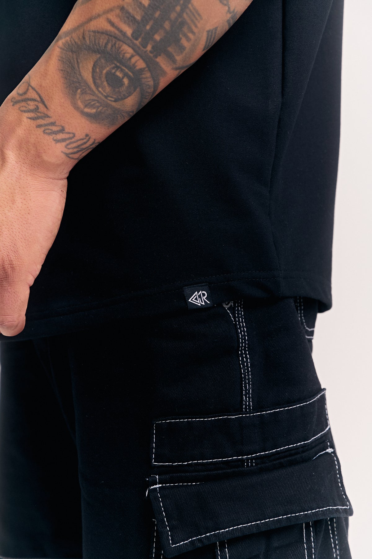 Black Eternal relaxed fit t-shirt for men, hem and woven label close-up – Rewind Apparel Dubai