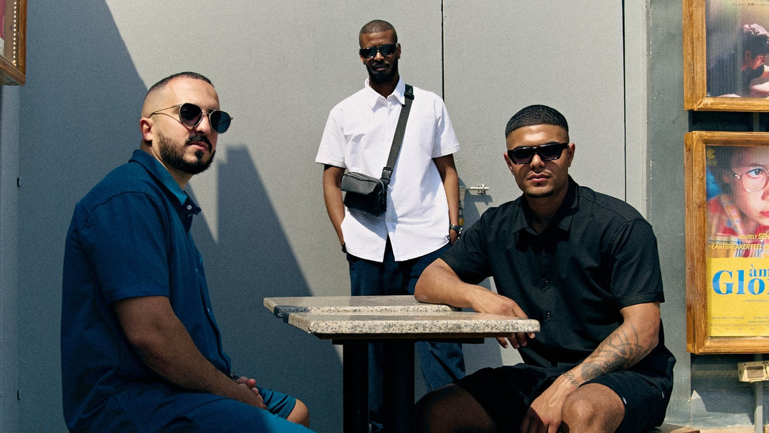 Three men in Prime short sleeve button-up shirts in pacific blue, white and black at a café table – Rewind Apparel Dubai