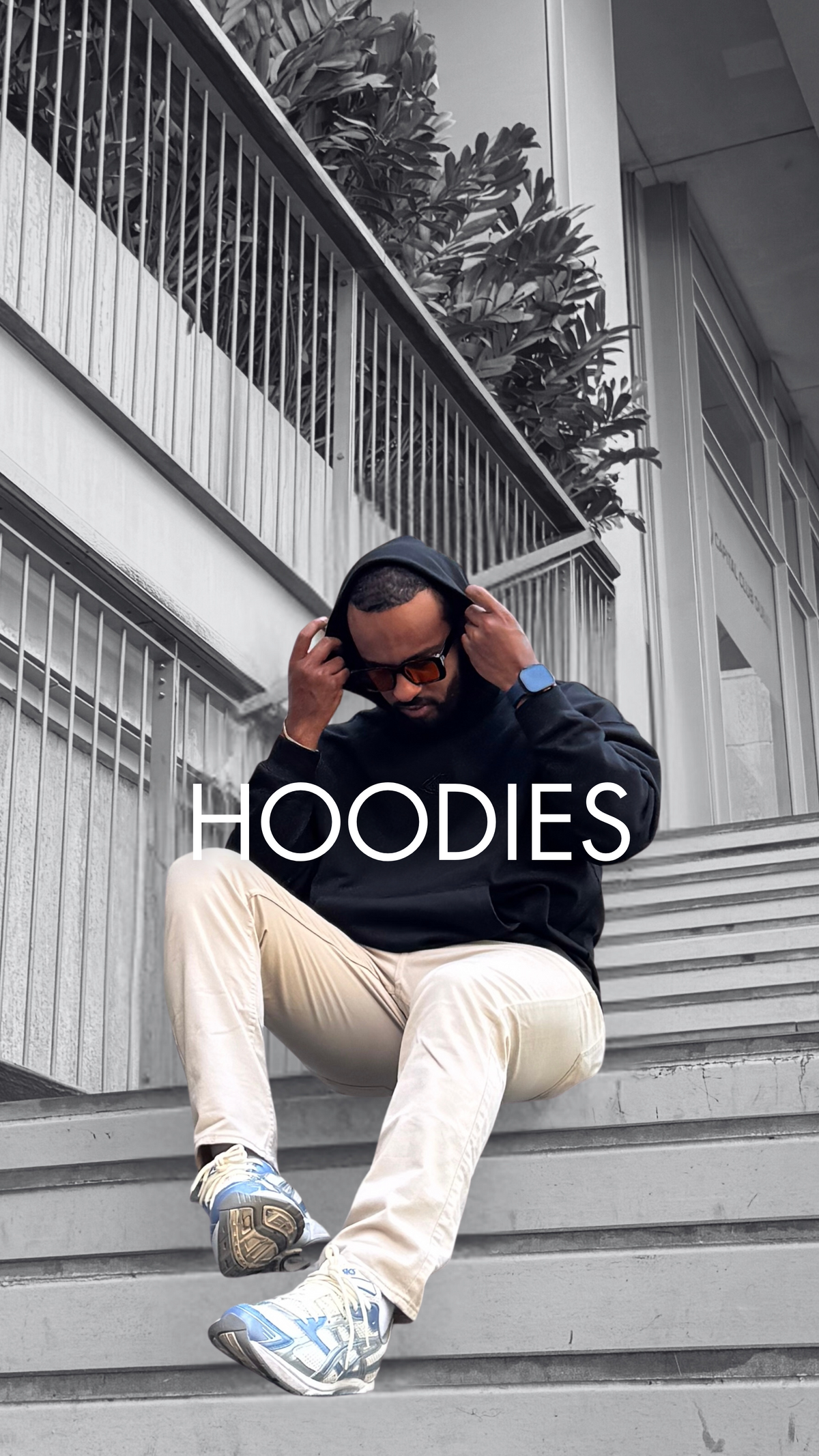 Man sitting on steps in a grey Rewind hoodie – men's hoodies by Rewind Apparel Dubai