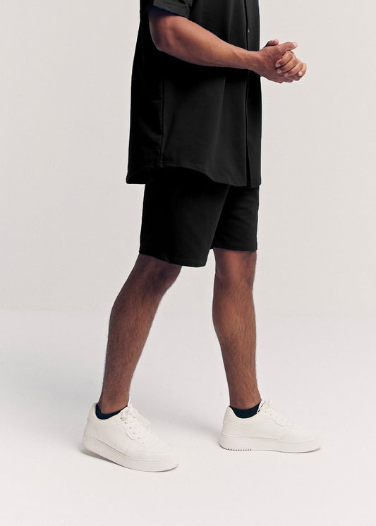 Black Classix regular fit shorts for men, side view on model – Rewind Apparel Dubai